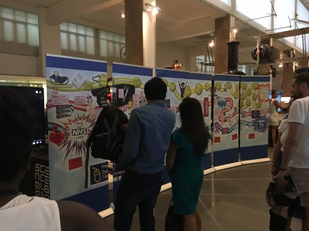 People looking at the NHS70 infographic at the National Science Museum